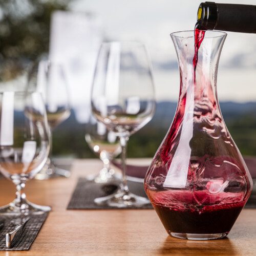 Red wine is poured into a decanter